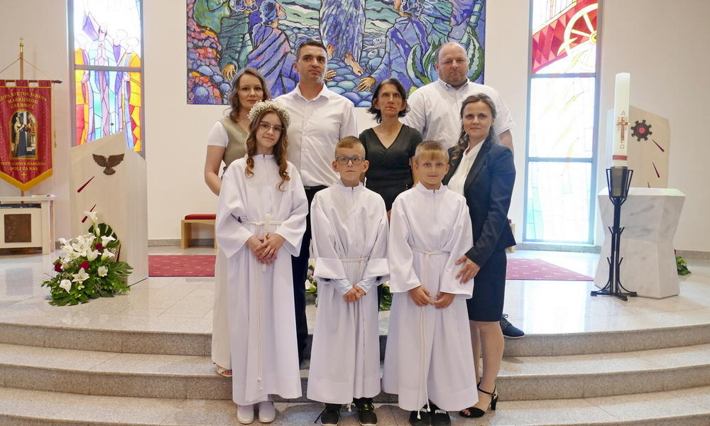 Prvopričesnici i njihovi roditelji u župi Grebnice, stoje za oltarom župne crkve.